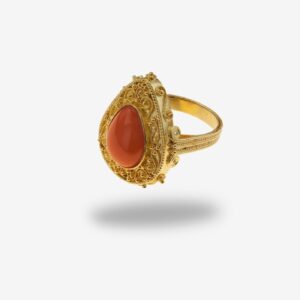 Gold ring with red gemstone, ornate design.