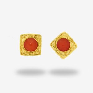 Gold earrings with red gemstone centers.