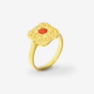 Gold ring with ornate red gemstone design.