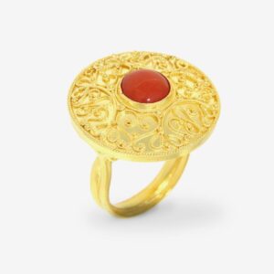 Gold ring with ornate design and red gemstone.