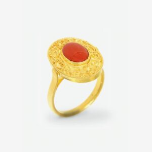 Gold ring with ornate red gemstone design.